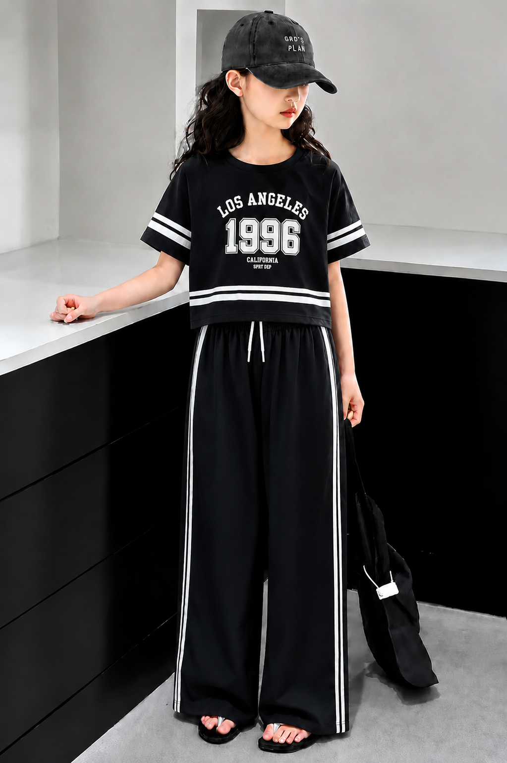 Black girls’ Los Angeles 1996 graphic co-ord set with wide-leg pants, stylish summer outfit for kids in Pakistan.
