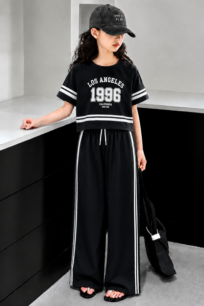Black girls’ Los Angeles 1996 graphic co-ord set with wide-leg pants, stylish summer outfit for kids in Pakistan.
