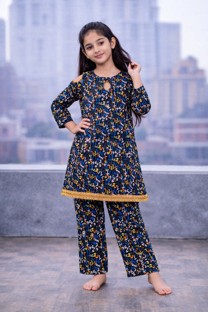 Black colorful printed cotton 2-piece outfit for girls with cut-out sleeve kurti and straight pants, balcony setting Pakistan
