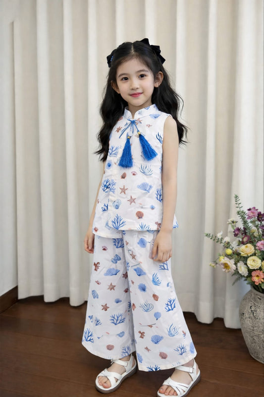 White cotton girls co-ord set with blue print and tassel top indoor.