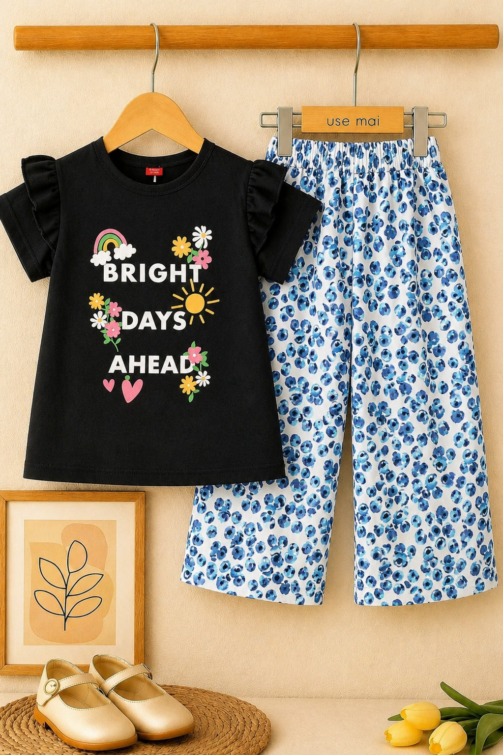 Girls black “Bright Days Ahead” printed cotton t-shirt with blue floral wide leg trousers co-ord set, stylish summer outfit for kids in Pakistan.
