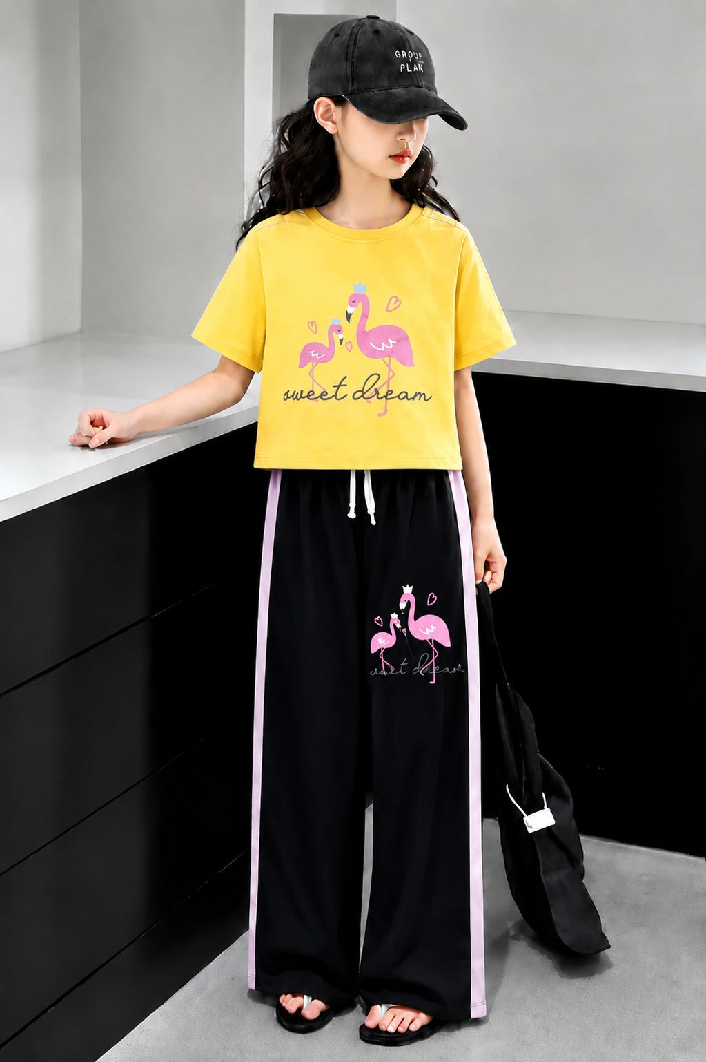 Mustard yellow girls flamingo print co-ord set with crop t-shirt and black wide leg trousers in Pakistan.
