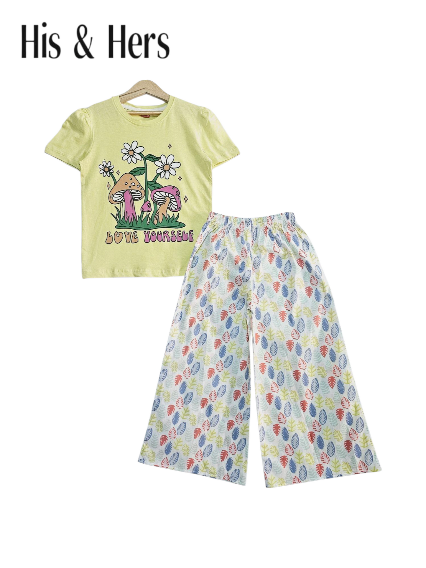 Yellow cotton girls co-ord set with graphic printed short sleeve t-shirt and multicolor leaf printed wide-leg pants, studio background Pakistan
