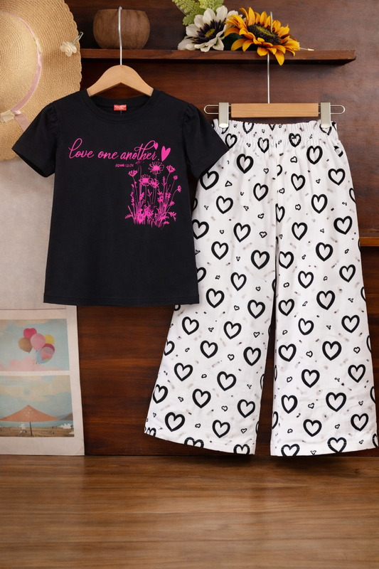 Black graphic cotton t-shirt with white heart print pants girls outfit on hanger.