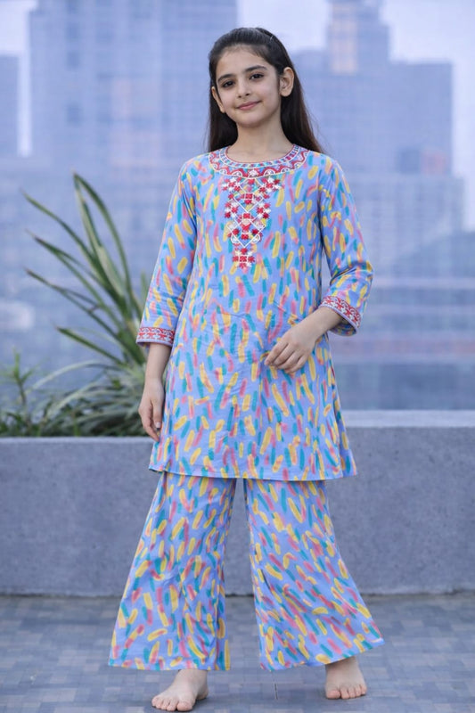 Blue printed cotton 2-piece outfit for girls with embroidered neckline kurti and wide-leg pants, balcony setting Pakistan

