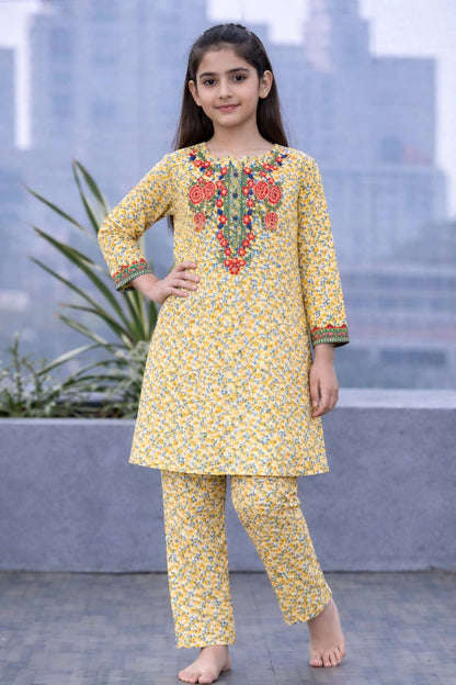 Yellow floral printed cotton 2-piece outfit for girls with embroidered neckline kurti and straight pants, balcony setting Pakistan
